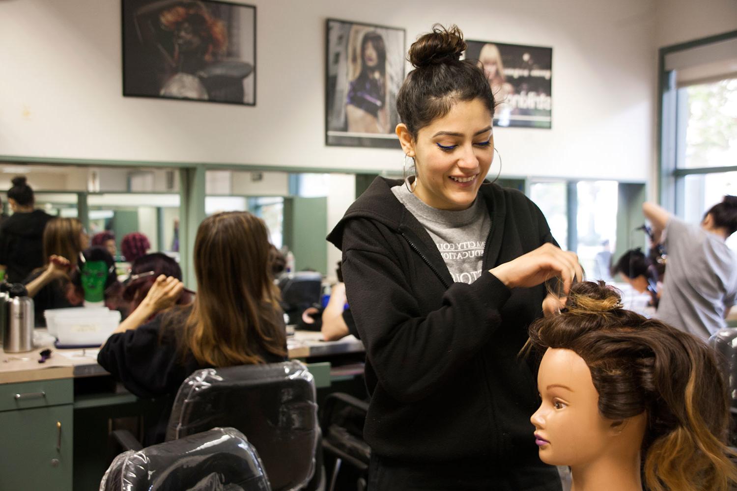 Cosmetology student works during class.