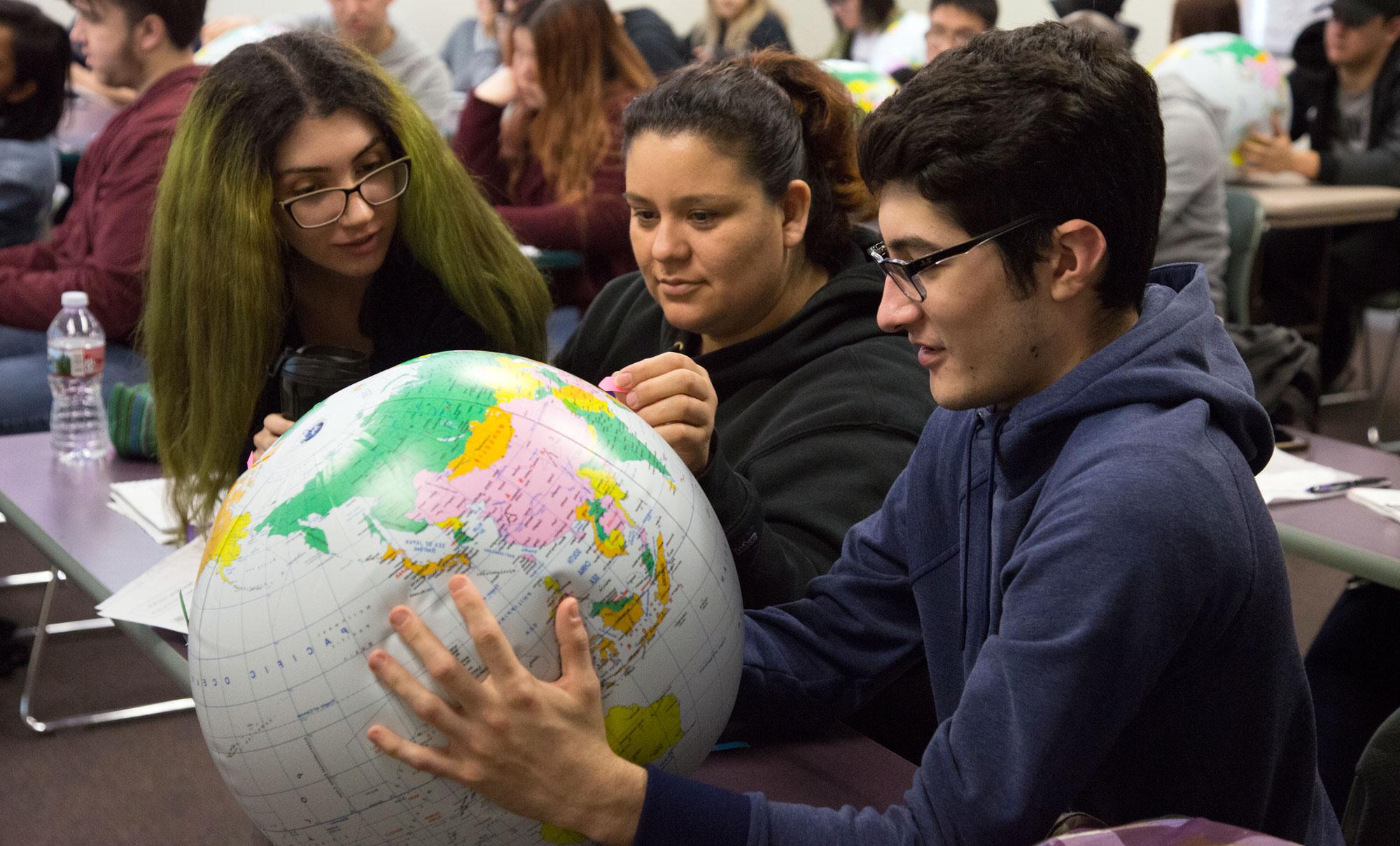 学生们在课堂上学习地球仪